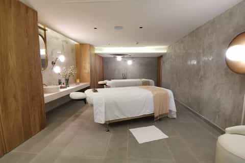 Spa treatment room with two massage beds and modern amenities