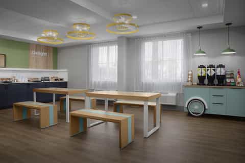 Modern cafeteria with wooden tables, white benches, turquoise accents, pendant lights, and large bright windows