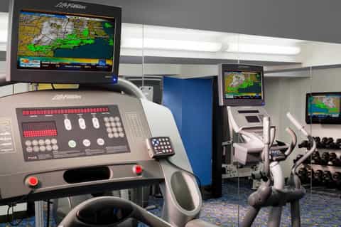 Fitness center with treadmills, Life Fitness equipment, monitors, and weights