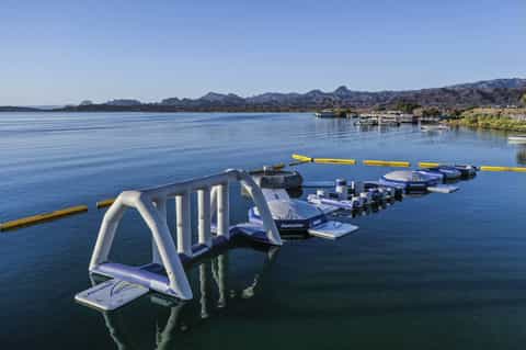 Water sports equipment setup on calm blue lake with mountains in background and waterfront buildings