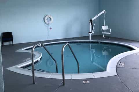 Indoor hot tub with metal railings and spa facilities in minimalist room setting