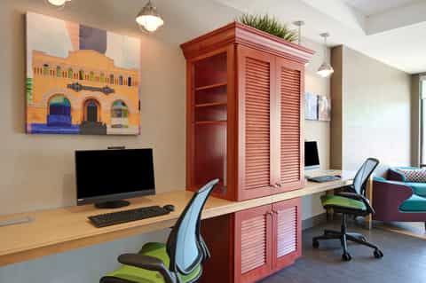 Modern business center with desk, computer, red cabinet, and office chairs