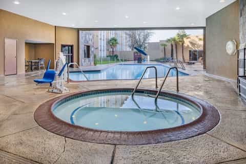 Indoor aquatic center with hot tub, lap pool, spa facilities, and poolside lounge areas