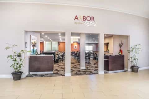 Arbor Grille restaurant entrance with orange accent walls and dining area visible
