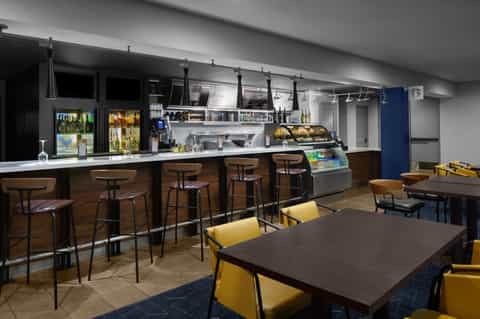 Casual cafe with counter seating, Starbucks signage, and yellow dining chairs