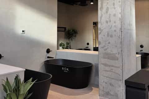 Spa bathroom with black freestanding soaking tubs and white marble accents