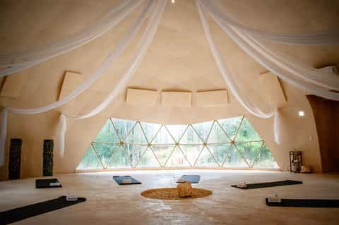 Modern spa or meditation room with sheer fabric draping, geometric skylight, and wooden flooring