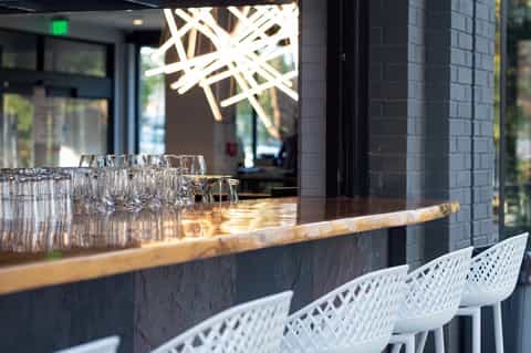 Modern bar counter with glasses and geometric ceiling light fixture