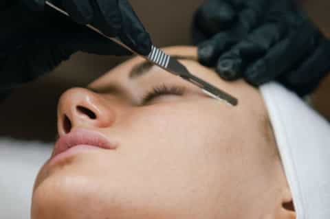 Close-up of facial treatment being applied with brush during spa procedure