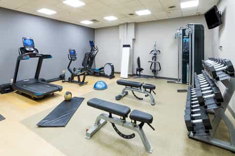 Well-equipped fitness center with treadmills, exercise bikes, dumbbells, and strength training equipment
