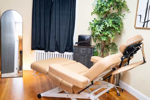 Modern spa treatment room with cream dental chair and natural lighting
