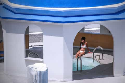 Indoor spa pool area with curved white walls, blue ceiling, and stepped entry
