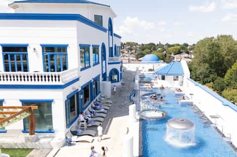 Mediterranean-style resort with blue and white architecture, rooftop pool, and spa