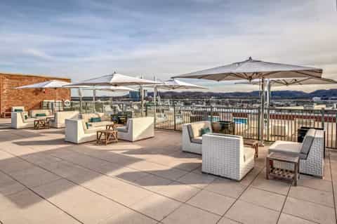Rooftop terrace with cream lounge seating, umbrellas, and panoramic valley views