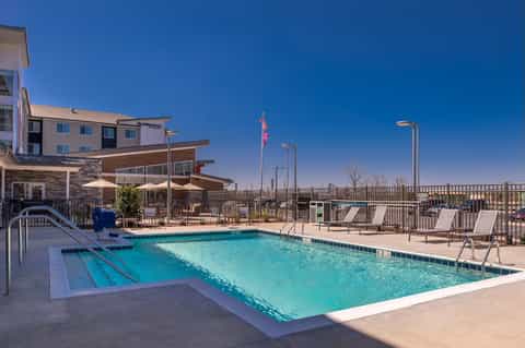 Resort outdoor pool with lap lane, lounge chairs, and desert landscaping