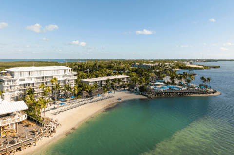 Beachfront resort with modern architecture, sandy beach, and turquoise water