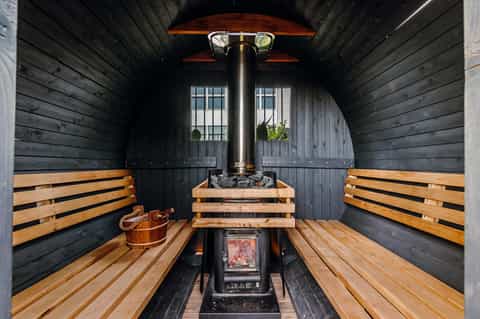 Interior of traditional wooden sauna with bench seating and central stove heater