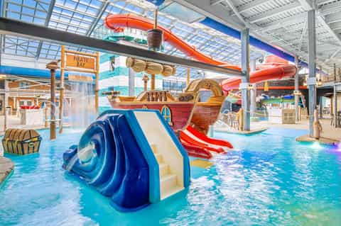 Indoor water park with pirate-themed slides, colorful water slides, and shallow pools for families