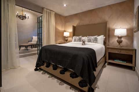Luxury bedroom with herringbone wood walls, upholstered headboard, and ambient lighting