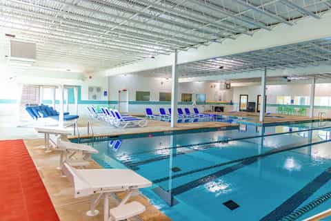 Indoor aquatic facility with Olympic-length pools, diving boards, and spacious lounging areas
