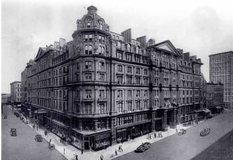 Historic black and white photograph of ornate Victorian corner building
