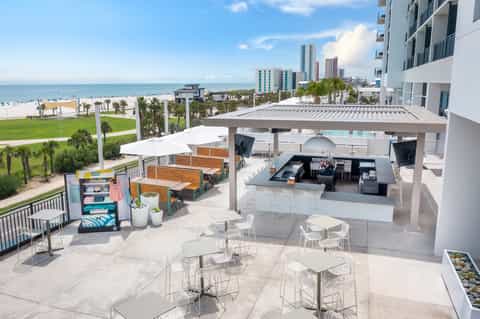 Rooftop bar and dining area overlooking beach, ocean, and coastal high-rises