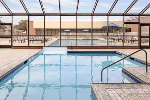 Indoor pool under glass enclosure with viewing windows and spa area