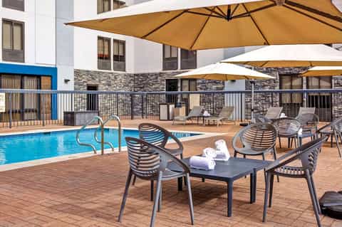 Resort pool deck with modern lounge chairs, umbrellas, and contemporary architecture