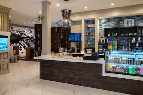 Modern Starbucks café interior with marble floors, black accents, and geometric pendant light
