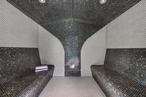Modern spa steam room with perforated metal walls in white and black geometric pattern design