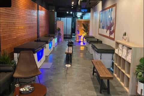 Modern cycling studio interior with stationary bikes, neon signage, accent lighting, and contemporary decor