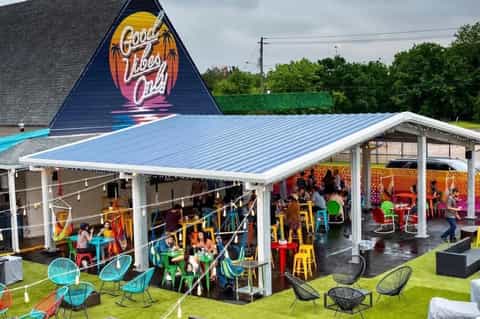 Colorful event pavilion with neon sign, outdoor seating, and modern canopy