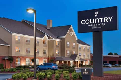 Country Inn & Suites exterior at dusk with brick and beige facade
