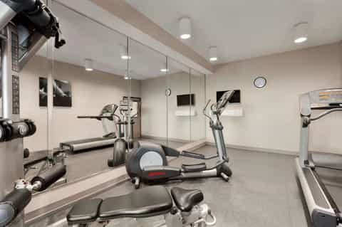 Modern fitness center with cardio equipment, mirrors, and LED lighting