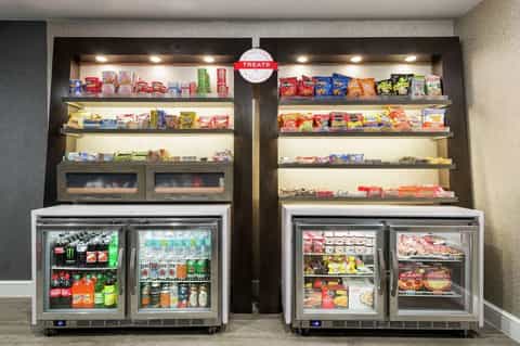 Vending station with refrigerated drink and food cases, snack shelves with illuminated display
