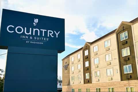 Country Inn & Suites by Radisson exterior sign with tan building and windows