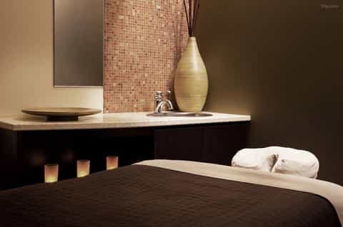 Spa massage room with ambient lighting, decorative vase, and relaxation ambiance