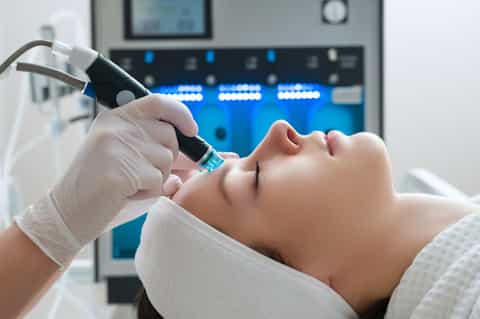 Medical aesthetic treatment on patient's face using microneedling device