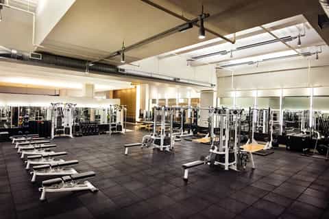 State-of-the-art fitness center with exercise equipment, mirrors, and modern ceiling design