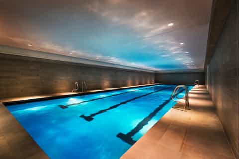 Indoor lap pool with lane dividers, ambient lighting, and sky ceiling