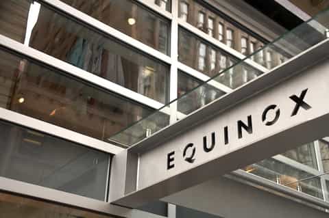 Equinox spa entrance with glass storefront and modern signage in urban setting