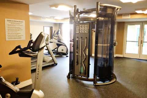 Modern fitness center with exercise equipment including elliptical machines and weight training apparatus