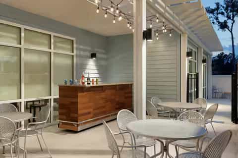 Resort bar and lounge area with wooden bar counter and modern patio seating