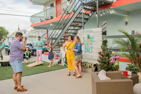 Family gathering outside colorful beachfront property with orange and green architectural features