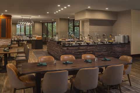 Executive lounge and breakfast buffet with serving stations, dining table, and nature views