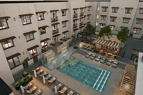 Aerial view of resort courtyard pool surrounded by multi-story residential buildings