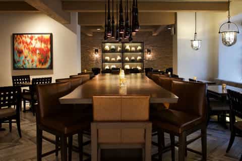 Conference room with long wood table, brown leather chairs, and modern lighting