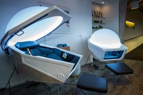 Modern wellness center with white high-tech cryotherapy and light therapy pods