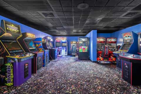 Vintage arcade game room with classic colorful gaming machines and patterned carpet flooring