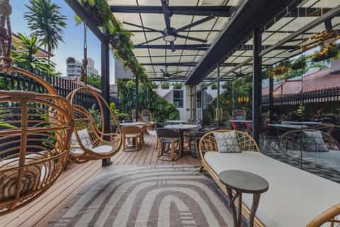 Rooftop terrace with wicker chairs, vertical gardens, and city skyline views